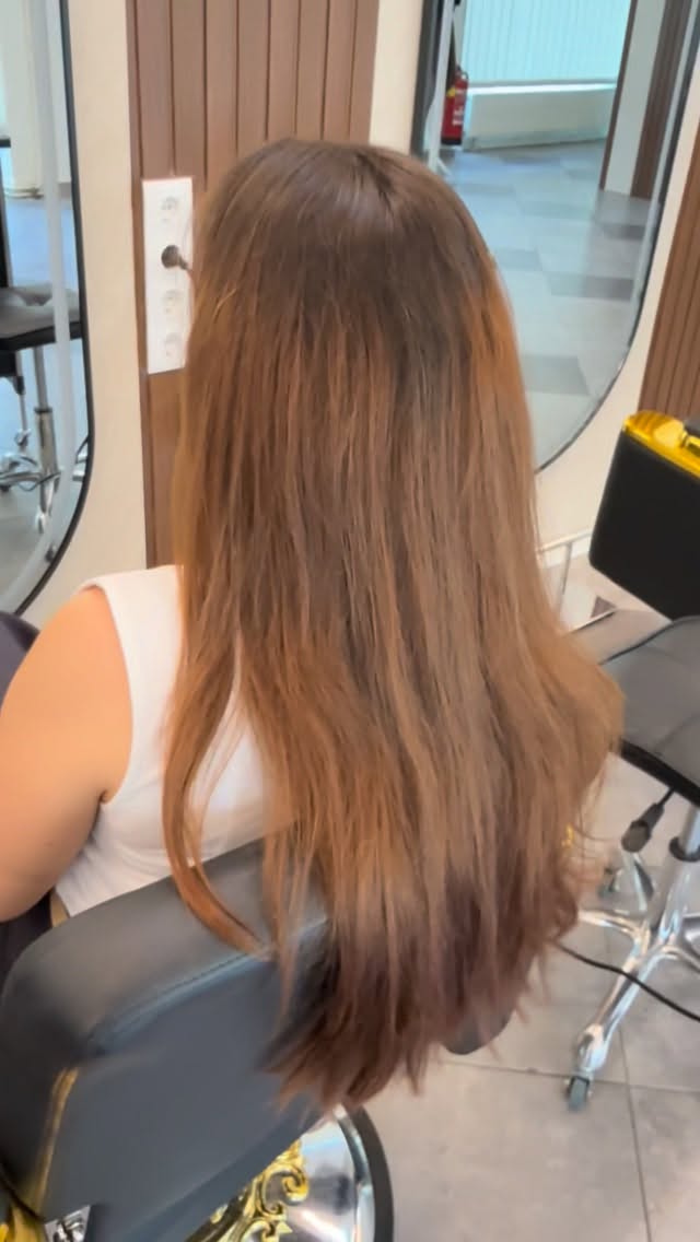 Lange karamellfarbene Haare nach Schnitt und Styling im Salon